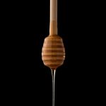 Maple Syrup running of honey spoon