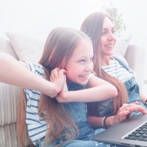 Girl and mom showing a positive Times Tales review by working with the program together on the computer.