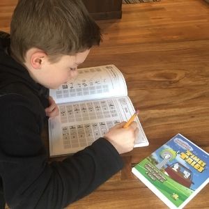 Boy using the Times Tales workbook and DVD to memorize multiplication facts.