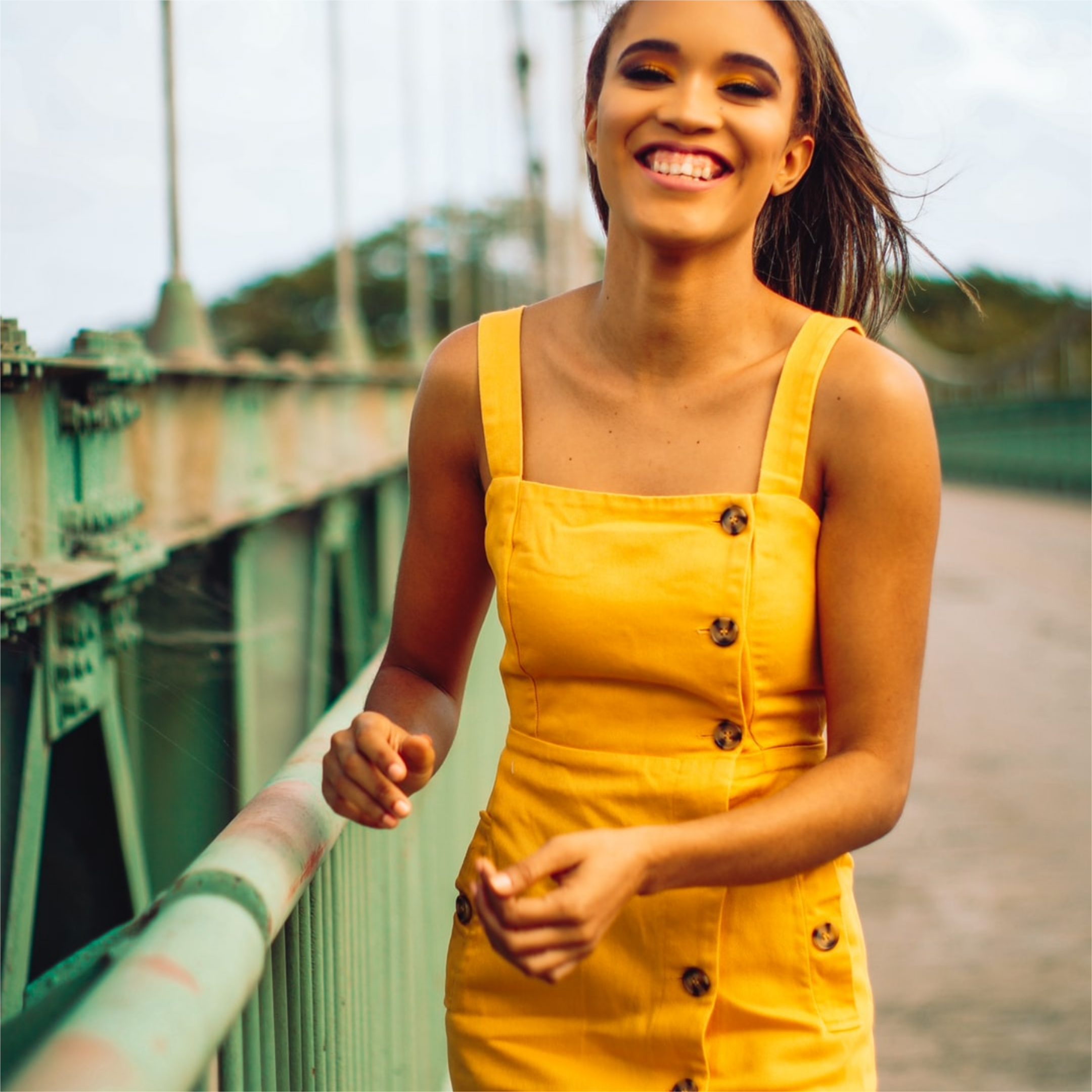 chica española en el puente sonriendo de éxito